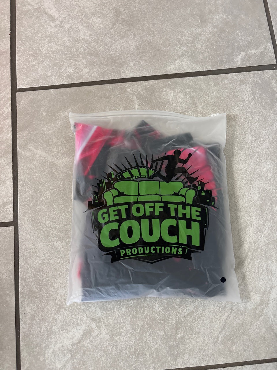 Ships in a resealable Get Off The Couch Productions logo bag